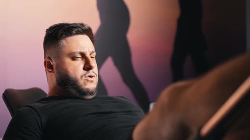 Strong young man training leg press machine at the gym