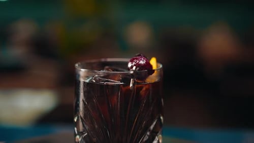 freshly prepared black alcoholic cocktail rotates on the bar counter in the bar-club