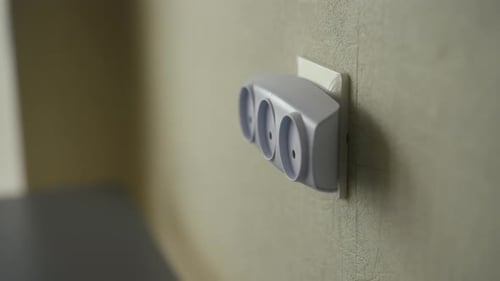 Closeup of Unrecognizable Man Removing Tee Outlet From Wall Socket at Home Concept of Disconnection