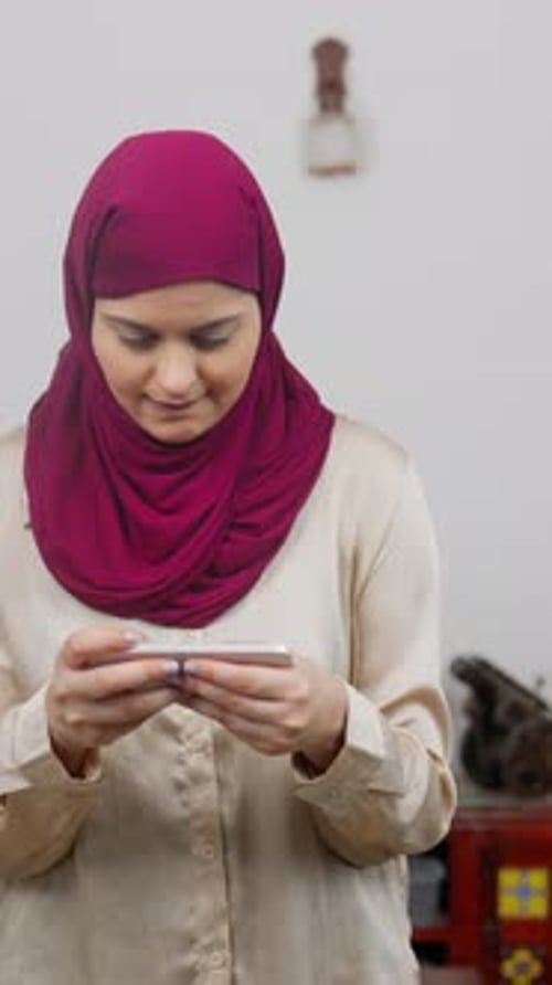 Vertical Video of Muslim Woman in Hijab Scarf Playing game on Phone