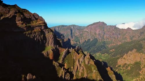 Spectacular mountains with sharp peaks. Sun lighting the slopes of the rocks. Azure sky at backdrop.