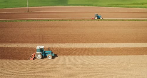 Toma aérea de un tractor agrícola que está arando y cultivando el campo para sembrar nuevas cosechas en un s.