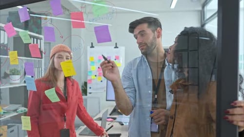 Diverse Team Brainstorming Ideas on Glass Wall