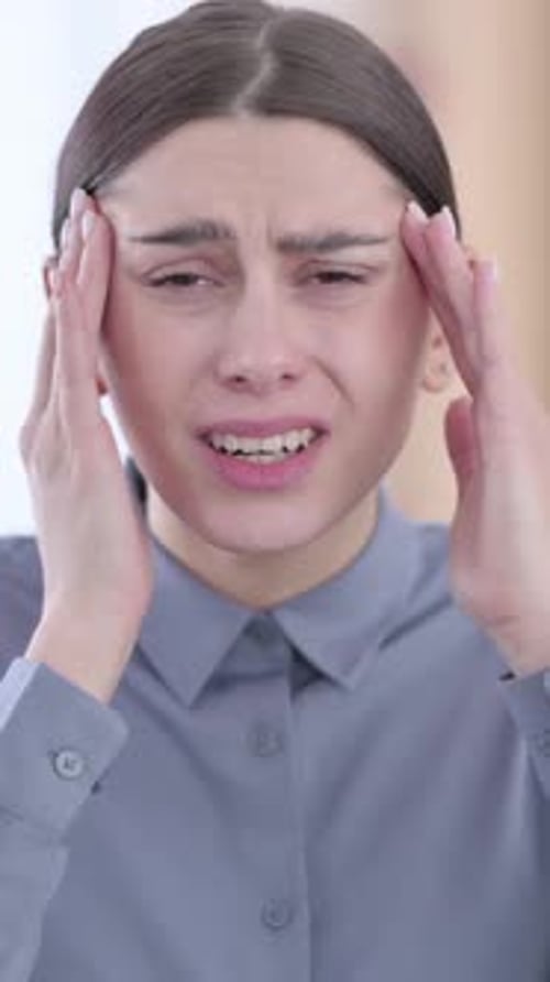 Woman Suffering from Headache Massaging Temples in Distress
