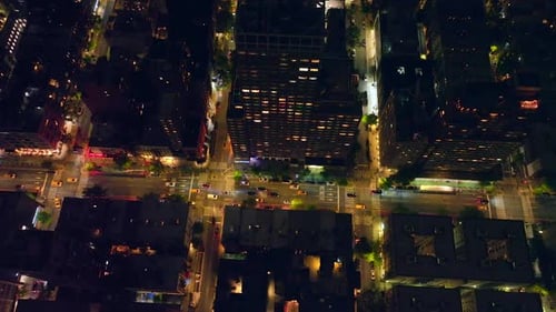 Cars crossing the numerous crossroads. Beautiful well-lit streets of New York at night. Top view.