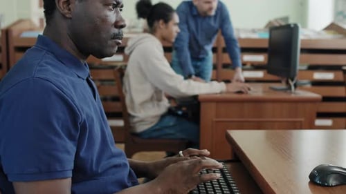 Senior Man Using Computer In Library