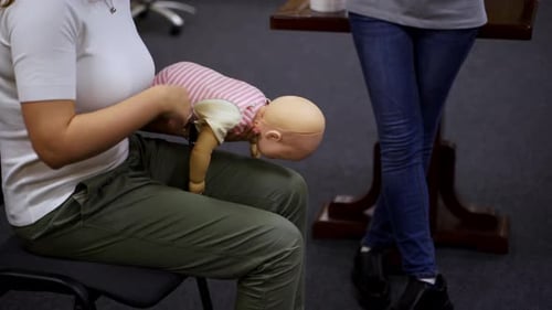 Adult Demonstrates Infant CPR on Mannequin
