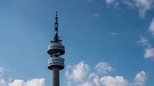 Time lapse video of TV tower with beautiful moving clouds in front of blue sky