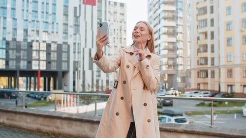 Mature Female Blogger Taking Selfie on Smartphone Communicating Video Call Online on Downtown Street