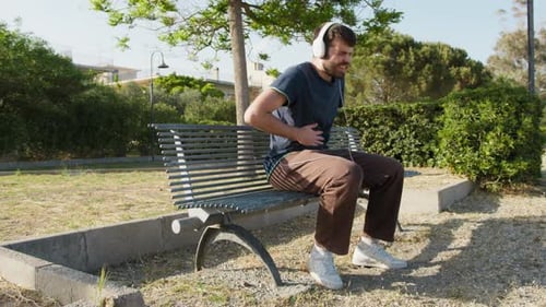 Man Sitting on Bench with Stomach Pain