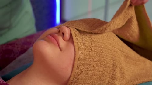 Woman Relaxing While Receiving a Facial Massage