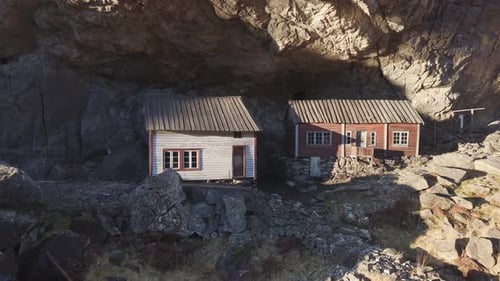 Two old houses under a cliff in Norway. Drone footage