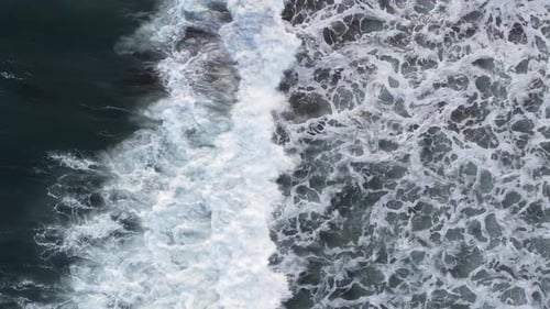 Top down aerial view of giant ocean waves crashing and foaming. pacific ocean, breaking waves, whit