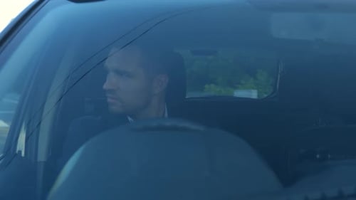 Young Businessman Holding a Steering Wheel While Driving a Car in the City Right Hand Drive Car
