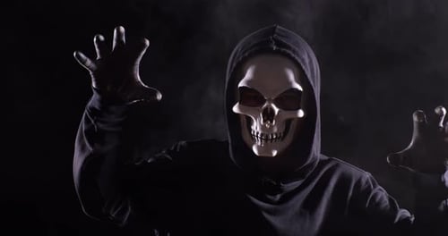 Close Up Of Scary Man In Halloween Mask On The Black Background With Smoke