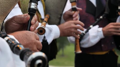 Detail von Händen, die in einer Volksgruppe in Zeitlupe den traditionellen galizischen Dudelsack spielen