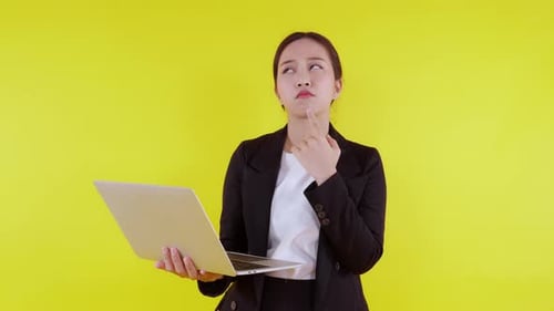 Portraittiere eine junge asiatische Geschäftsfrau mit Laptop und denke über Ideen für die Planung nach und entscheide mit Erfolg.
