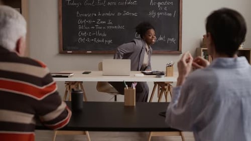 Woman Teaching Computer Skills to a Group of Adults