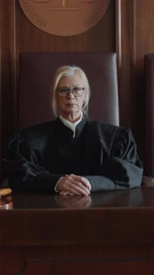 Woman in Judge Robes Sits at Bench