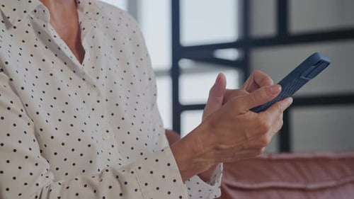 Unrecognizable Mature Woman Browsing on Smartphone Close Up