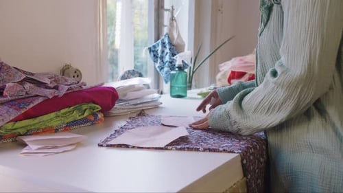 Woman Tracing Pattern onto Colorful Printed Fabric