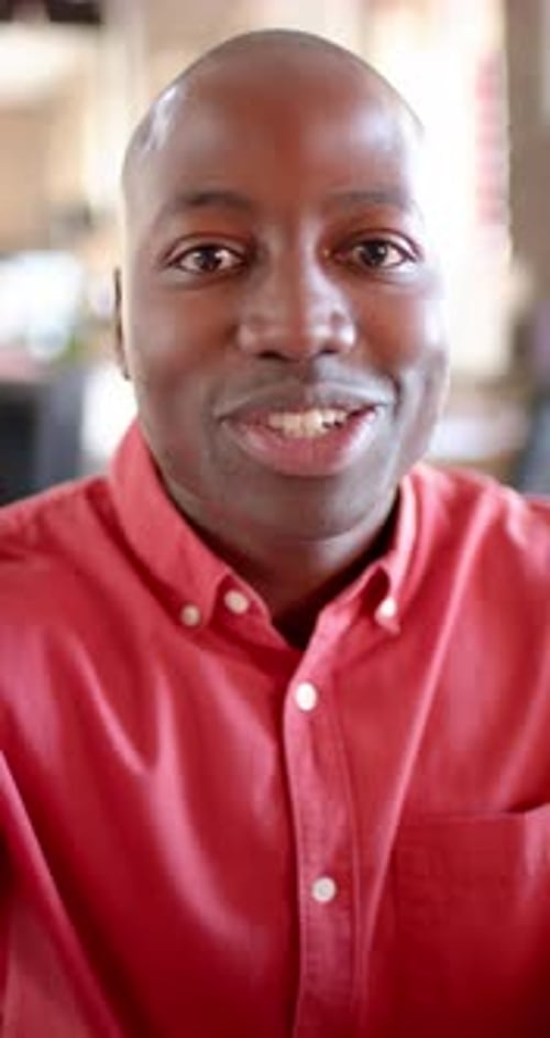 Man Talking to Camera Indoors Wearing Red Shirt