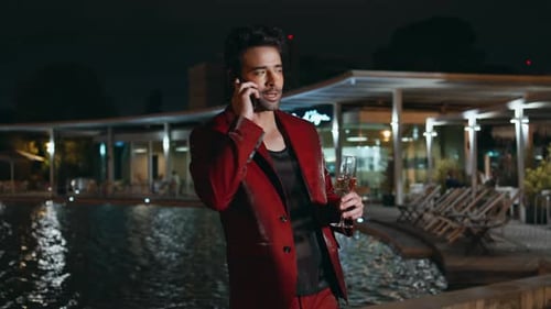 Glamorous Guy Calling Smartphone at Poolside Party Night Close Up Latin Macho