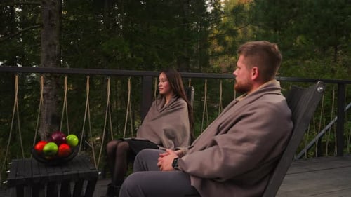 Man and Woman on Forest Hotel Terrace at Dusk