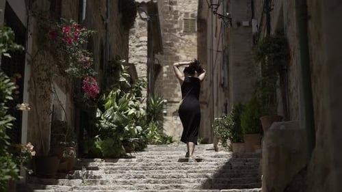 Woman Ascends Stone Steps in Urban Alley