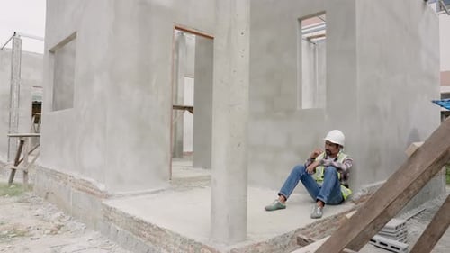 Foreman's Discouragement Sitting on cement wall at a construction site. stress because workers do no