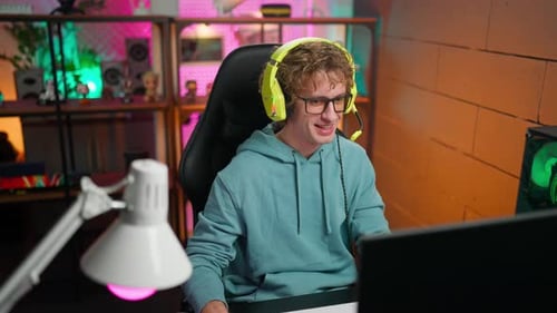 Young Adult Gamer Playing Computer Game At Home