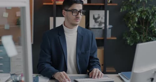 Young Adult Working on Computer at Office Desk