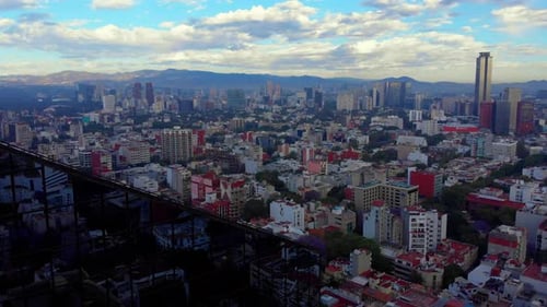 stunning Mexico City cityscape urban neighborhood skyline tall buildings mountains cloudy sky mornin