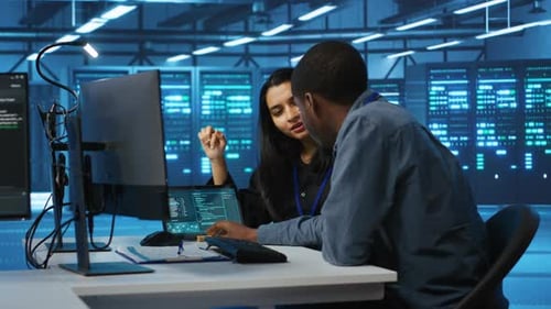 Diverse Team of Engineers Looking at Parameters in Data Center on Tablet