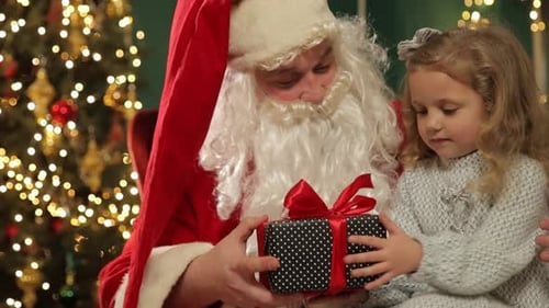 Santa Claus giving gift to child in Christmas setting