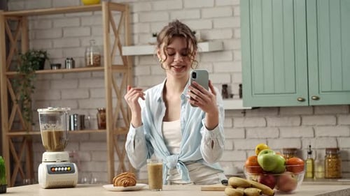 Woman Video Calling Holding Smoothie in Kitchen