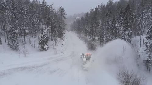 Tractor Snowblower Working On A Countryside Road With Winterly Atmosphere. Aerial Drone Shot