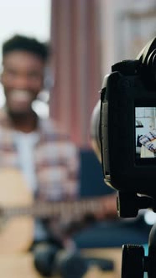View Through Camera Lens Where Likable Smiling Happy Young Blackskinned Male Guitarist Enjoying His