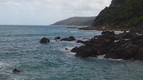 4K Aerial rocks in the water near the coast - Drone dolly in shot