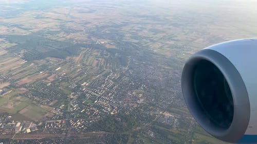 Turbine Engine Of An Airplane Flying In High Altitude Above Vast Landscape. close up, POV