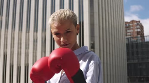 Stylish Businesswoman Posing with Boxing Gloves Outdoors