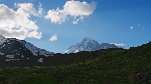 Timelapse of Kazbegi Mountain in Caucasus Snowcapped Peak Moving Clouds Rich Green Slopes Dawn to