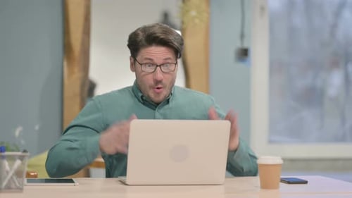Man Cheering at Computer in Modern Office