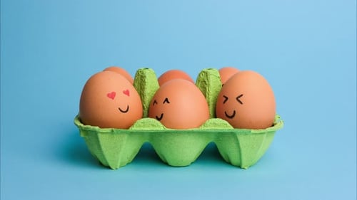 Cute Easter Eggs with Funny Faces in Green Box Isolated on Blue Background