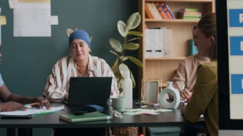 Four Adults Meeting in Workplace Discussing Ideas