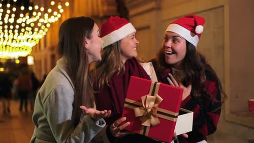 Friends Gathered, Opening Christmas Present on City Street