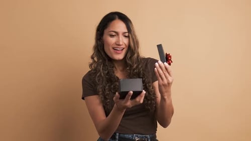 Woman Opens Gift Box, Excited and Happy