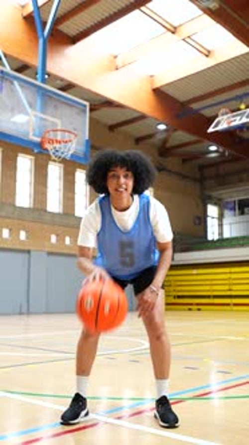 Female Basketball Player Dribbling and Posing on Court