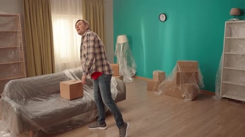 Man Moving Cardboard Box Into New Home