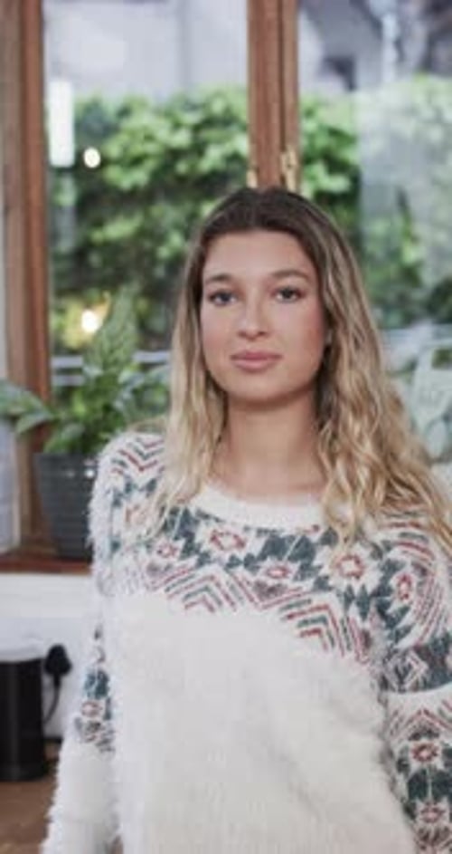Smiling Woman Wearing a Colorful Sweater Indoors